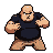 Stout, muscular fighter in a dark t-shirt, fists clenched in a defensive stance on a checkered background.