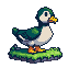 A plump, cheerful duck with emerald green and white feathers stands on green grass, its yellow beak open.