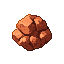 Rough, angular chunks of copper ore in deep reds and warm oranges, with a pixelated texture.