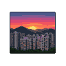 Pixelated cityscape at sunset with purple, orange, and pink sky, silhouetted mountains, and a lone tower.