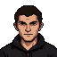 Stern-faced man with dark, tousled hair, wearing a dark hooded garment, in a retro pixelated portrait style.