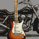 Sunburst electric guitar with cream pickguard and fretboard in front of a dark, chrome-accented motorcycle.