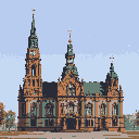 This pixel art image showcases a grand, ornate church or municipal building with impressive spires and intricate architectural details. The building's symmetrical design and warm color palette evoke a sense of historical dignity under a clear, light blue sky.