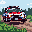 A pixelated rally car drifts around a dirt track, captured in a dynamic, retro-style image. The red, white, and blue race car evokes classic arcade racing vibes with its blocky design and implied speed.